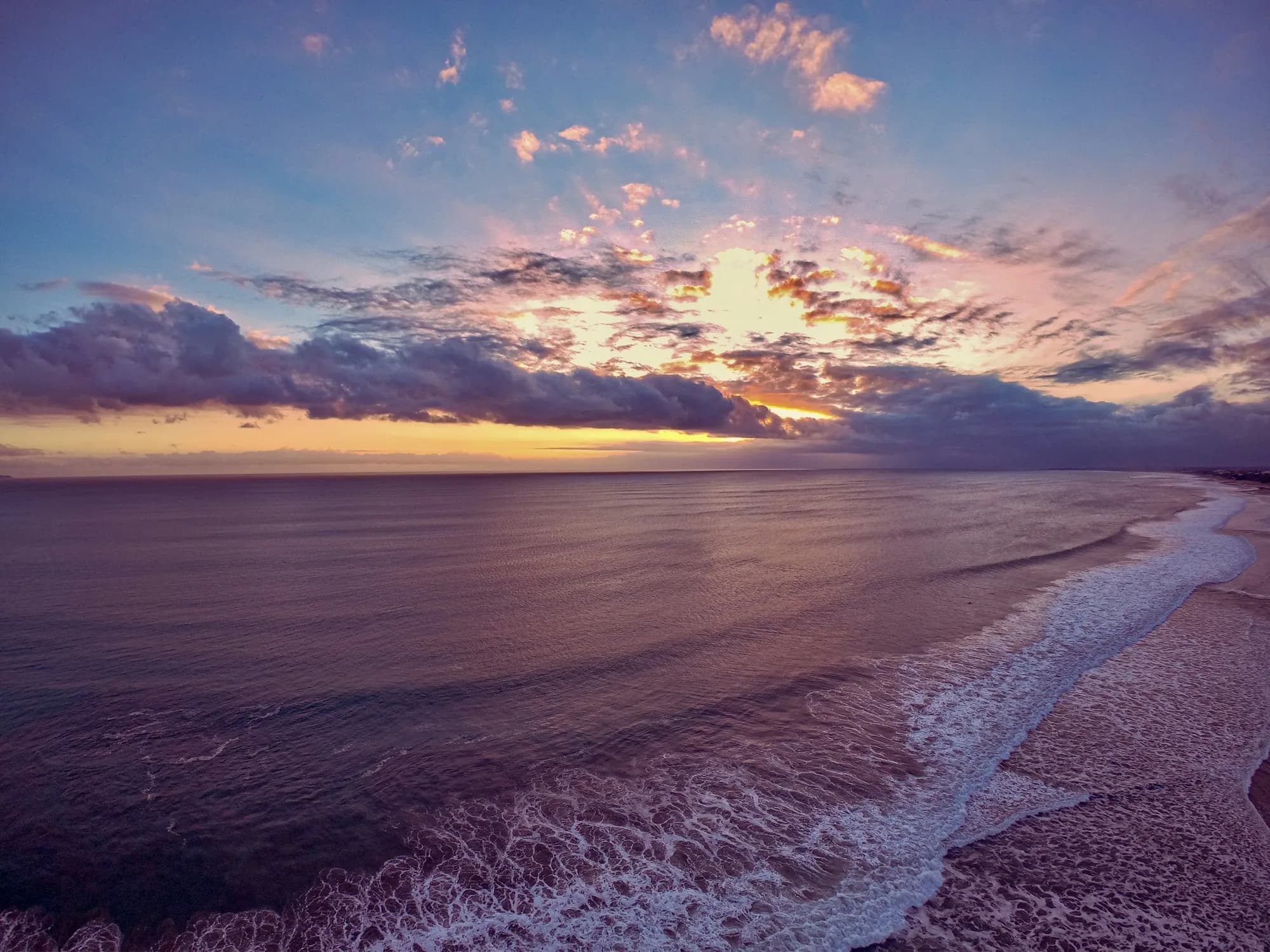 Waves rolling onto Seminyak beach at sunset, Bali